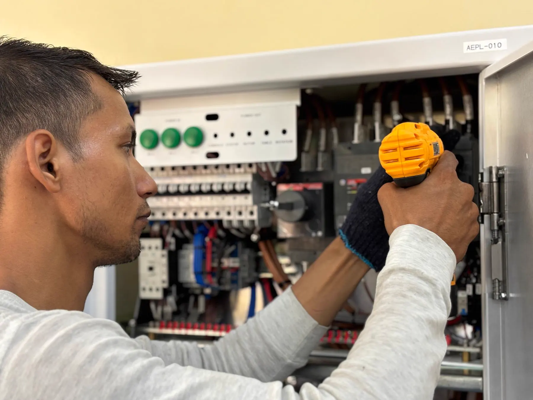 Technician examining connections in an electrical panel